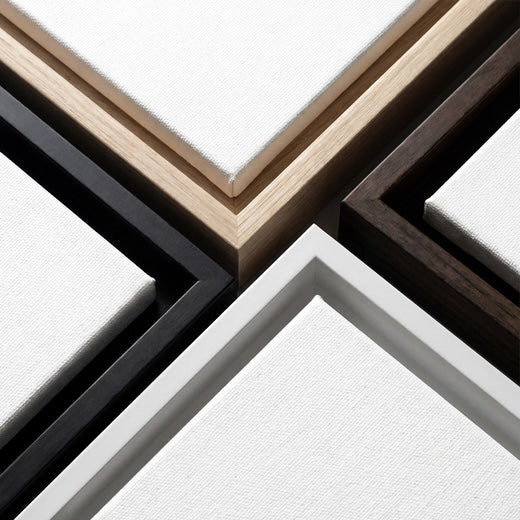 4 pinewood frame finishes — Black, Walnut-Tone, Oak-Tone, White — close-up mosaic showing all available options. All 3 canvases in your trio ship in the same finish.